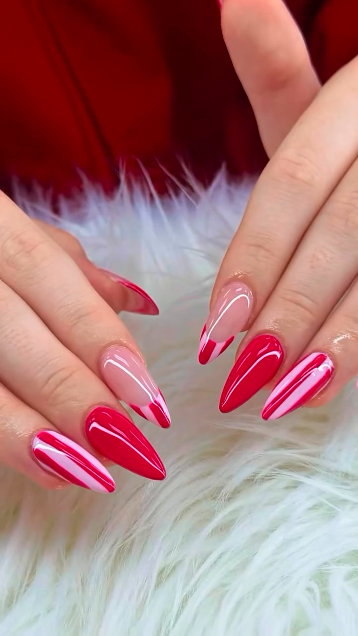 Glossy red and pink striped stiletto nails on white fur